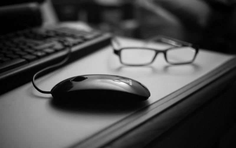 Компьютерная мышь и очки на столе
